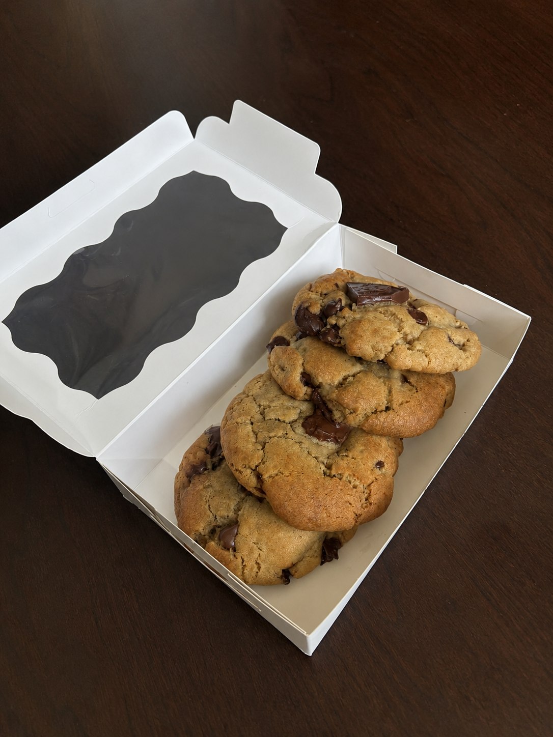 Brown butter chocolate chip cookies arranged inside an open bakery box